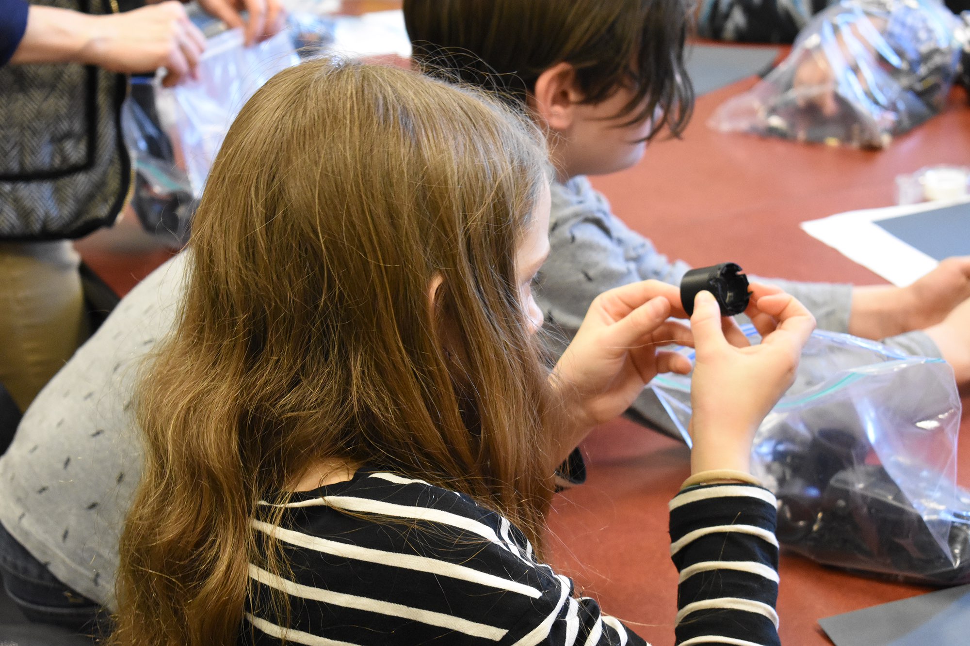 Student examines disassembled electronic pieces